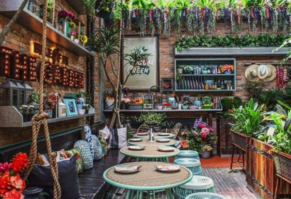 Cafe dengan nuansa alam dan taman vertikal yang memberikan kesan segar dan natural